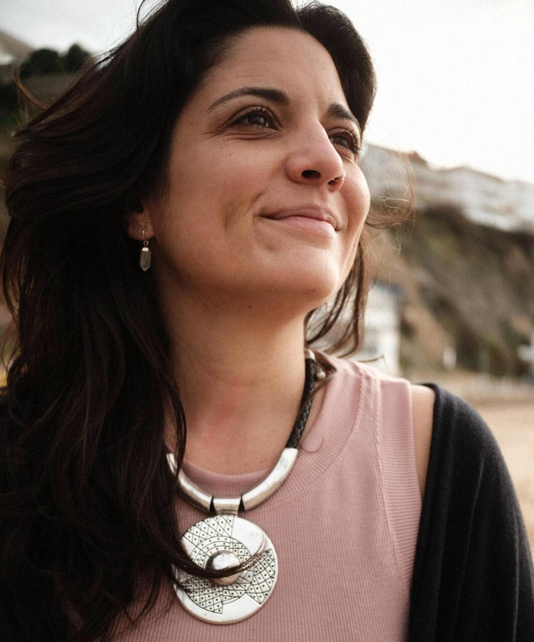 Transform within to create your life Flor, founder of Espacio Medrar, smiling and looking into the distance, embodying hope and transformation through self-awareness – Thriving Sessions